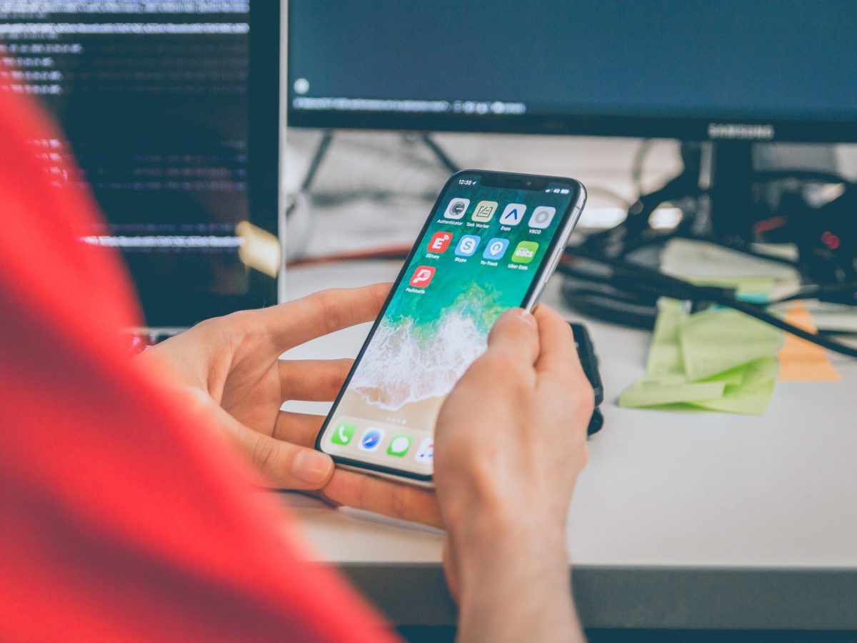 Programmer holding phone while coding